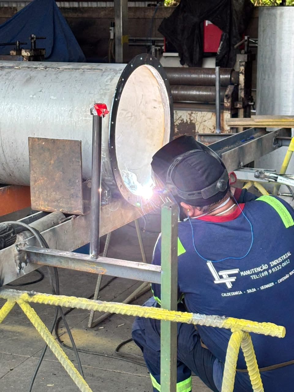 Soldador da LF trabalhando em flange de duto na oficina